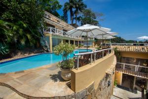 a resort with a swimming pool and a building at Pousada e Spa Villa Mercedes by Latitud Hoteles in Búzios