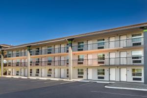 an apartment building with white doors and a parking lot at SureStay Hotel by Best Western Clermont Theme Park West in Kissimmee