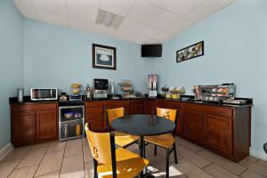 a kitchen with a table and a table and chairs at SureStay Hotel by Best Western Clermont Theme Park West in Kissimmee