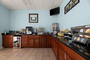 a kitchen with wooden cabinets and a counter top at SureStay Hotel by Best Western Clermont Theme Park West in Kissimmee