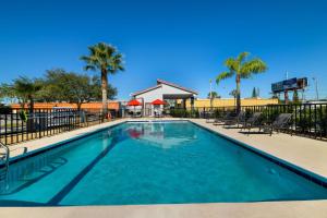a swimming pool at a resort with palm trees at SureStay Hotel by Best Western Clermont Theme Park West in Kissimmee