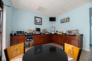 a kitchen with a black table and two chairs and a table at SureStay Hotel by Best Western Clermont Theme Park West in Kissimmee