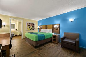 a hotel room with a bed and a desk and a chair at SureStay Hotel by Best Western Clermont Theme Park West in Kissimmee