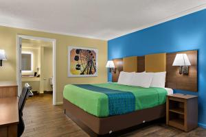 a hotel room with a large bed and a bathroom at SureStay Hotel by Best Western Clermont Theme Park West in Kissimmee