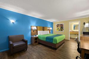 a hotel room with a bed and a chair at SureStay Hotel by Best Western Clermont Theme Park West in Kissimmee