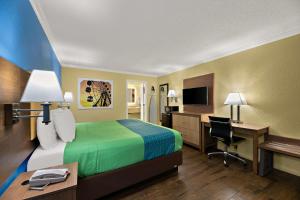 ein Hotelzimmer mit einem Bett und einem Schreibtisch in der Unterkunft SureStay Hotel by Best Western Clermont Theme Park West in Kissimmee