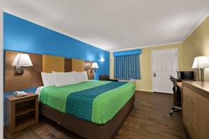 a hotel room with a bed and a desk at SureStay Hotel by Best Western Clermont Theme Park West in Kissimmee