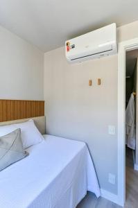 a bedroom with a white bed with a white blanket at Apartamento Moderno Paulista Sirio in Sao Paulo