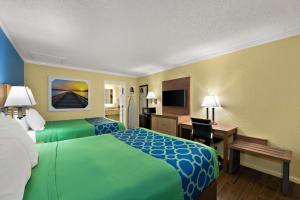 a hotel room with two beds and a desk at SureStay Hotel by Best Western Clermont Theme Park West in Kissimmee