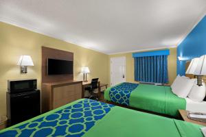 a hotel room with two beds and a flat screen tv at SureStay Hotel by Best Western Clermont Theme Park West in Kissimmee