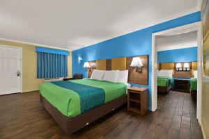 a hotel room with a large bed and a bathroom at SureStay Hotel by Best Western Clermont Theme Park West in Kissimmee