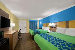 a hotel room with two beds and a flat screen tv at SureStay Hotel by Best Western Clermont Theme Park West in Kissimmee