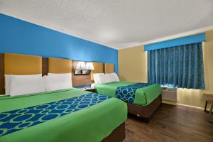 a hotel room with two beds and a window at SureStay Hotel by Best Western Clermont Theme Park West in Kissimmee