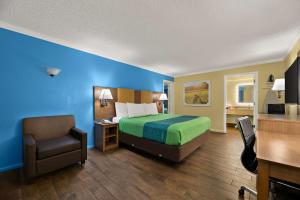a hotel room with a bed and a chair at SureStay Hotel by Best Western Clermont Theme Park West in Kissimmee