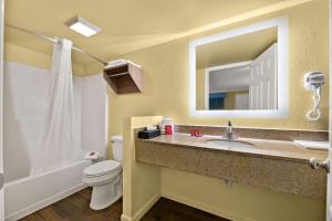 a bathroom with a sink and a toilet and a mirror at SureStay Hotel by Best Western Clermont Theme Park West in Kissimmee