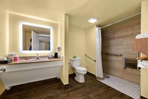 a bathroom with a toilet and a sink and a mirror at SureStay Hotel by Best Western Clermont Theme Park West in Kissimmee