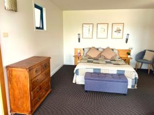 Cloud Nine Apartment @ Tamar Ridge في Grindelwald: غرفة نوم مع سرير وخزانة خشبية ودرج