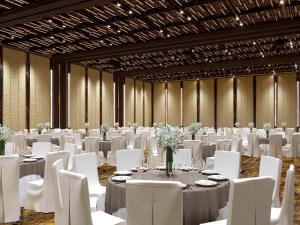 a banquet hall with white tables and white chairs at Mövenpick Resort Waverly Phu Quoc in Phu Quoc