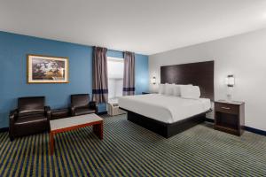 a hotel room with a bed and a chair at SureStay Plus by Best Western Brooks in Brooks +29 photos