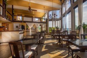 a restaurant with tables and chairs and large windows at Pousada e Spa Villa Mercedes by Latitud Hoteles in Búzios