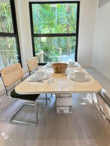 uma mesa e cadeiras num quarto com uma janela em Coconut Grove Mid-Century Jungle Oasis em Miami