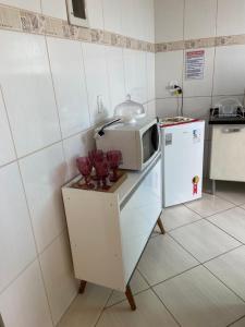 a kitchen with a microwave and a refrigerator at Apartamento Centro Alfenas in Alfenas