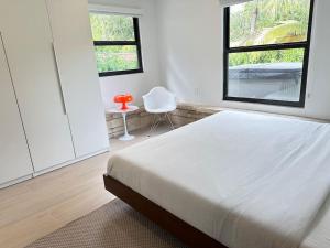 - une chambre blanche avec un lit et une fenêtre dans l'établissement Coconut Grove Mid-Century Jungle Oasis, à Miami