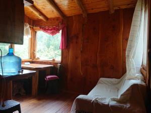 um quarto com uma cama, uma mesa e uma janela em La Cabañita em Tanti