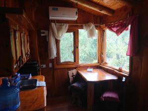 タンティにあるLa Cabañitaのテーブルと窓が備わる小さな客室です。