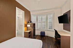 a bedroom with a bed and a desk with a computer at Mithila San Francisco - SureStay Collection by Best Western in San Francisco