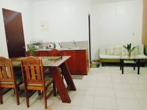 a kitchen with a table and chairs and a couch at Mariana Condotel in Puerto Princesa City