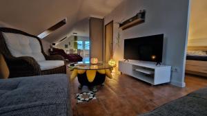 a living room with a tv and a coffee table at Surforama Studio Appartement mit Meerblick und Garten in Fehmarn