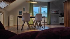 ein Esszimmer mit einem Tisch und 2 Stühlen in der Unterkunft Surforama Studio Appartement mit Meerblick und Garten in Fehmarn