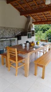 a wooden table and chairs in a kitchen at Chale Jatoba Monteiro Lobato in Monteiro Lobato