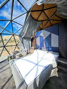 Cama en habitación con ventana grande en Clear Sky Resorts - Bryce Canyon - Unique Stargazing Domes, en Cannonville
