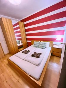 ein Schlafzimmer mit einer rot-weißen gestreiften Wand in der Unterkunft Opera Residence in Budapest