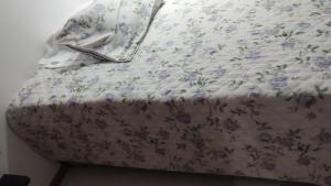 Una cama con flores púrpuras con una sábana en Apartamento MEDELLIN, en Medellín