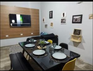 comedor con mesa negra y sillas en Nature House en Jarinu
