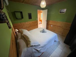 a bedroom with a white bed with green walls at Cabaña Terra Calma in Vistalba +14 photos