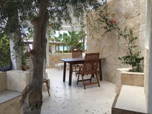 a table and chairs on a patio with a tree at Beach Villa am Praia de Chaves, Sal Rei, Boa Vista in Boa Ventura