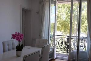 a dining room with a table with a vase of flowers at Eiffel Tower Oasis 30m from Eiffel Tower in Paris