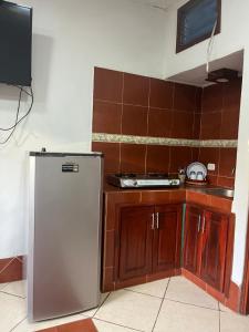 a kitchen with a stainless steel refrigerator and wooden cabinets at Apartamento El Madroño in León