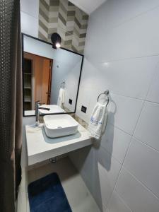 uma casa de banho com um lavatório e um espelho em HOTEL LUXOTEL PISCO em Pisco