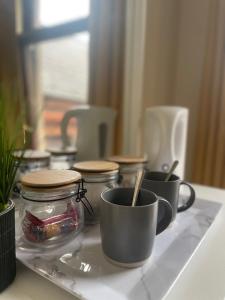 a counter with two cups and a jar of food at House in Antrim road in Belfast