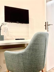 帕蘇約阿爾庫斯的住宿－HM - HouseMirage，一张椅子坐在桌子前面,配有电视