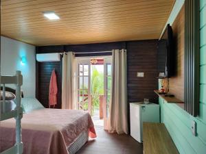 Un dormitorio con una cama y una puerta corrediza de vidrio. en Beto Pousada, en Penha