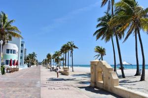 a person walking on a beach with palm trees at Modern Home - Termpurpedic Queen bed, Laundry, Free Parkging, EV Tesla in Hollywood