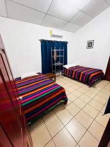 um quarto com 2 camas sentado num piso de azulejo em Casa de playa “mi lancho” em La Libertad