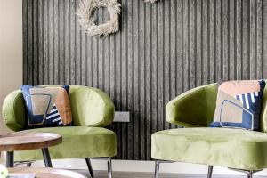 two green chairs with pillows on them in a room at Stylish Sanctuary in London in London