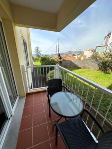 a balcony with a glass table and chairs on it at Apartamento Santiago I in Funchal